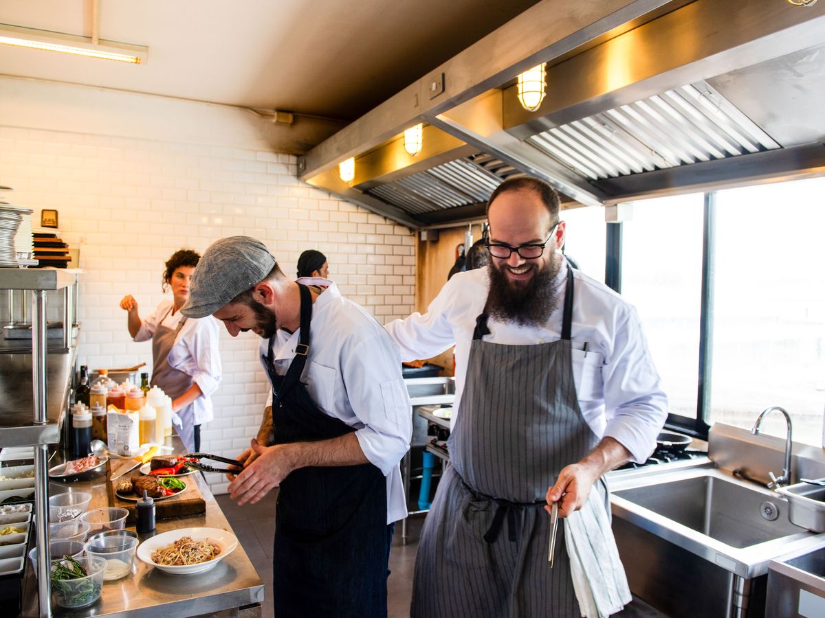 Chefs preparing food in a busy commercial restaurant kitchen