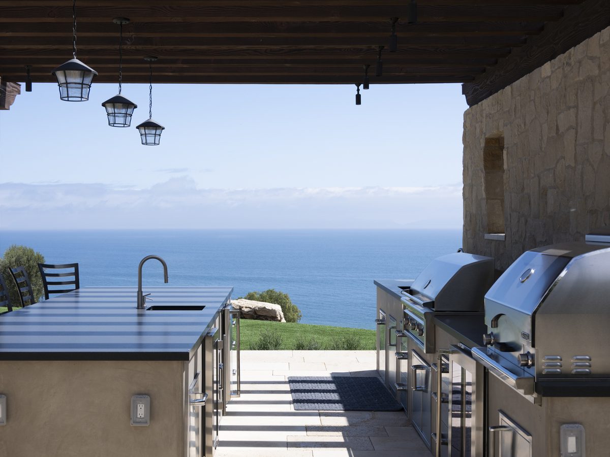 Outdoor kitchen with built-in stainless steel BBQs and an ocean view