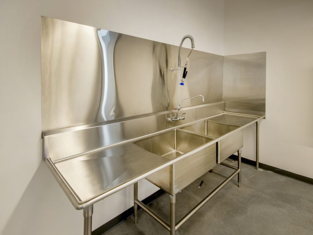 Stainless steel double-bowl sink bench with drain board, pre-rinse tap and backsplash