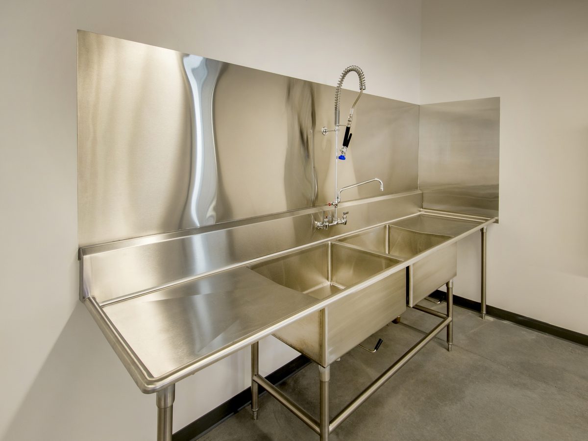 Stainless steel double-bowl sink bench with drain board, pre-rinse tap and backsplash