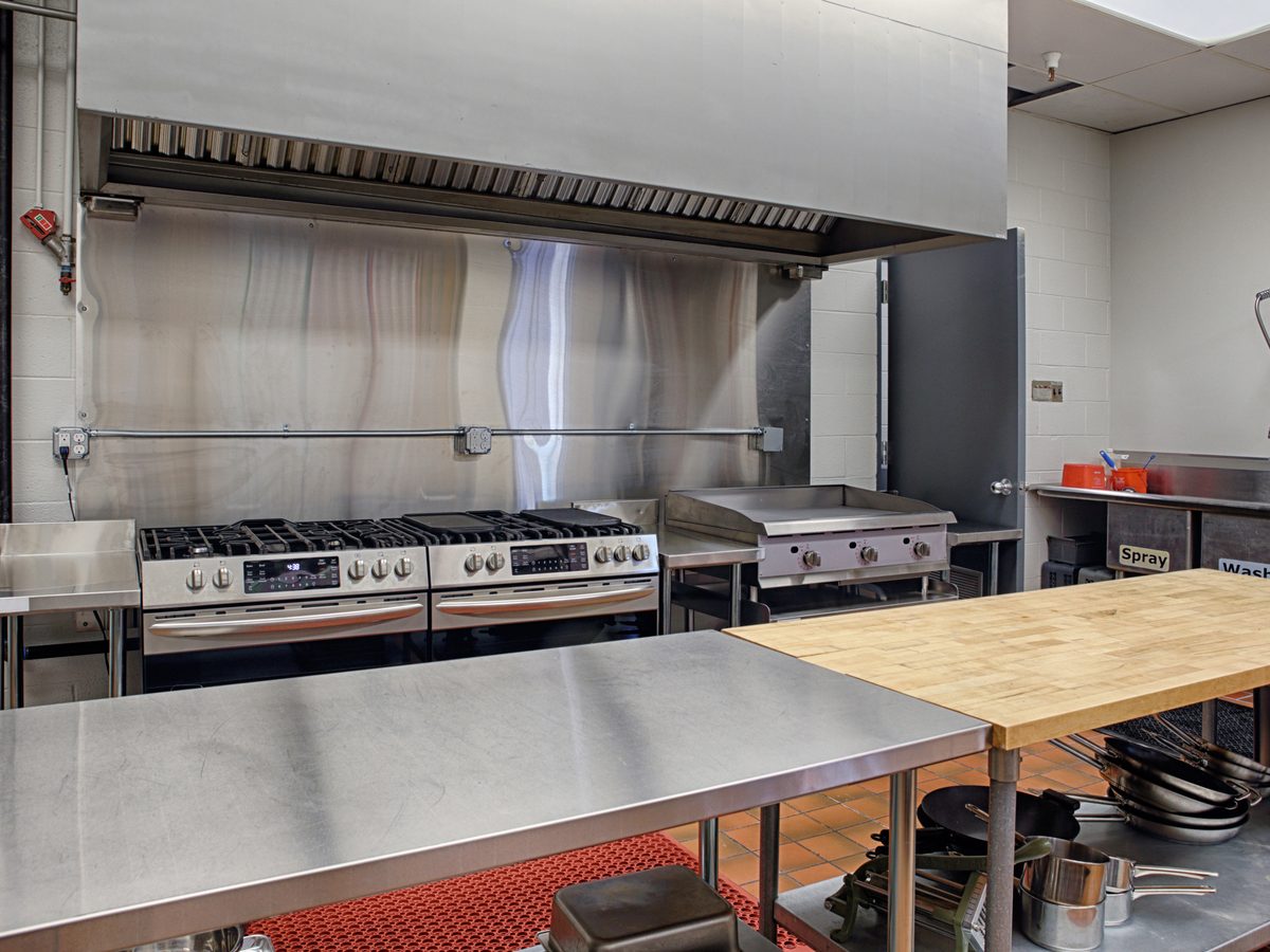 Stainless steel prep bench with undershelf in a commercial kitchen