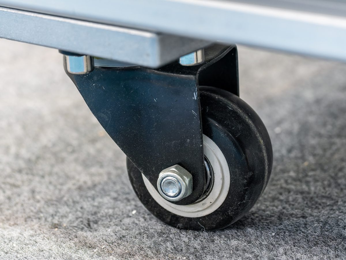 Close-up of a castor wheel fitted to a steel workbench frame