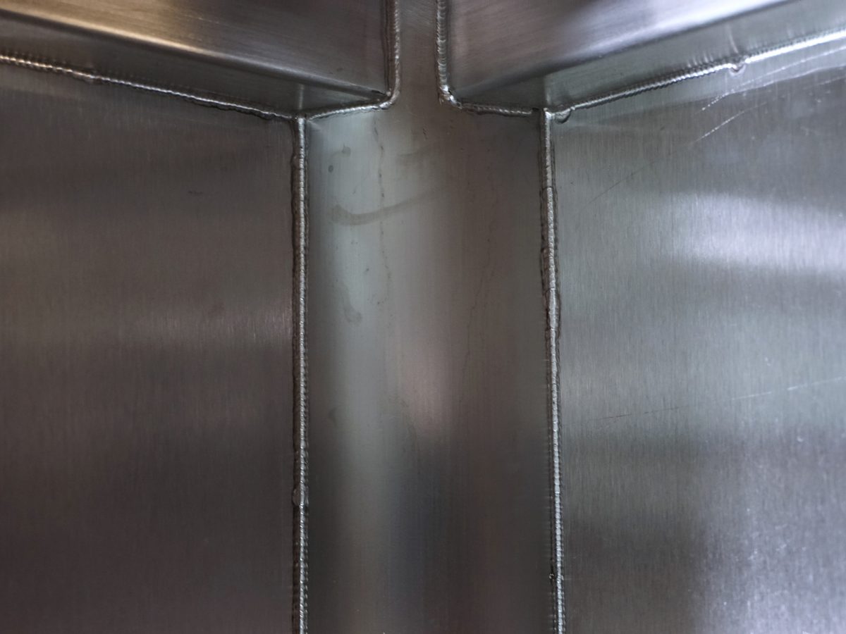 Close-up of welded internal corners in a stainless steel sink bowl